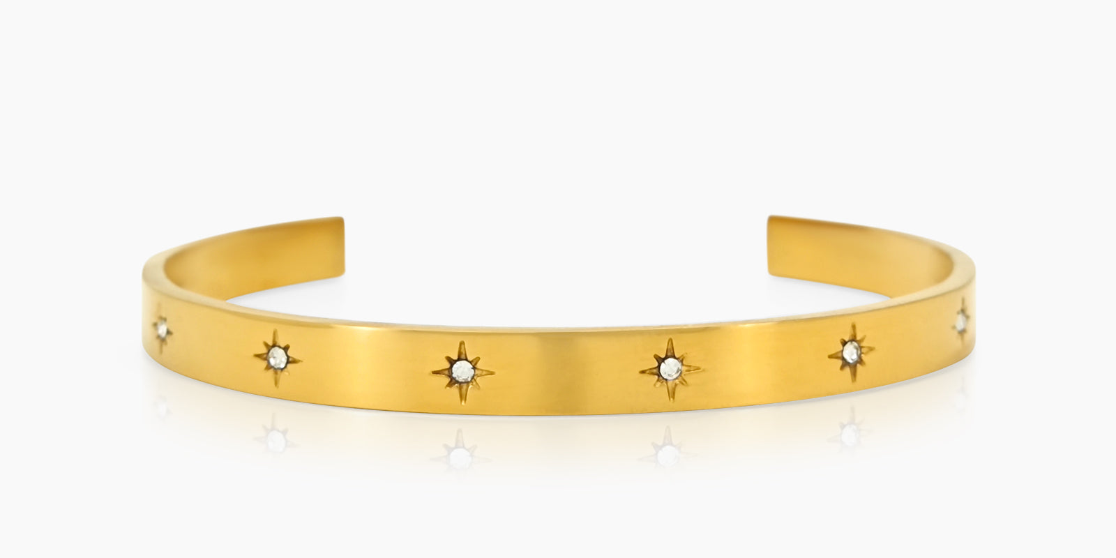 A gold bangle with a smooth, polished finish and tiny star-shaped engravings set with zircon stones