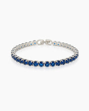 A classic tennis bracelet featuring vibrant, round-cut navy zircon stones in a sleek silver-tone channel