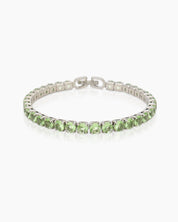 A classic tennis bracelet featuring vibrant, round-cut green zircon stones in a sleek silver-tone channel