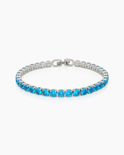 A classic tennis bracelet featuring vibrant, round-cut blue zircon stones in a sleek silver-tone channel