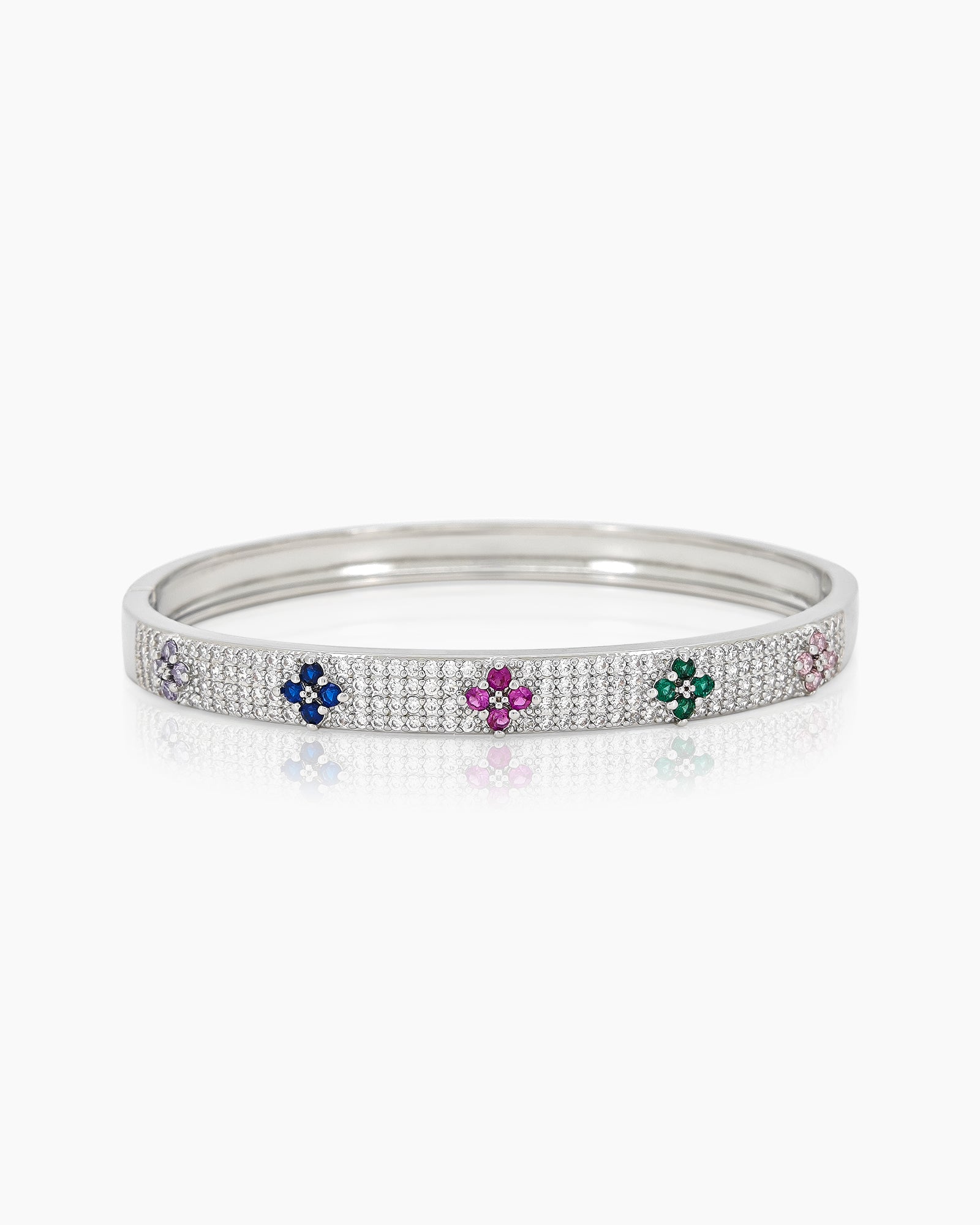 A silver bangle with a sleek silhouette, adorned with pavé-set crystals and playful multicolored floral motifs
