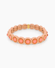 A peach-orange stretch bracelet with glossy links set with iridescent crystal stones for a playful flair