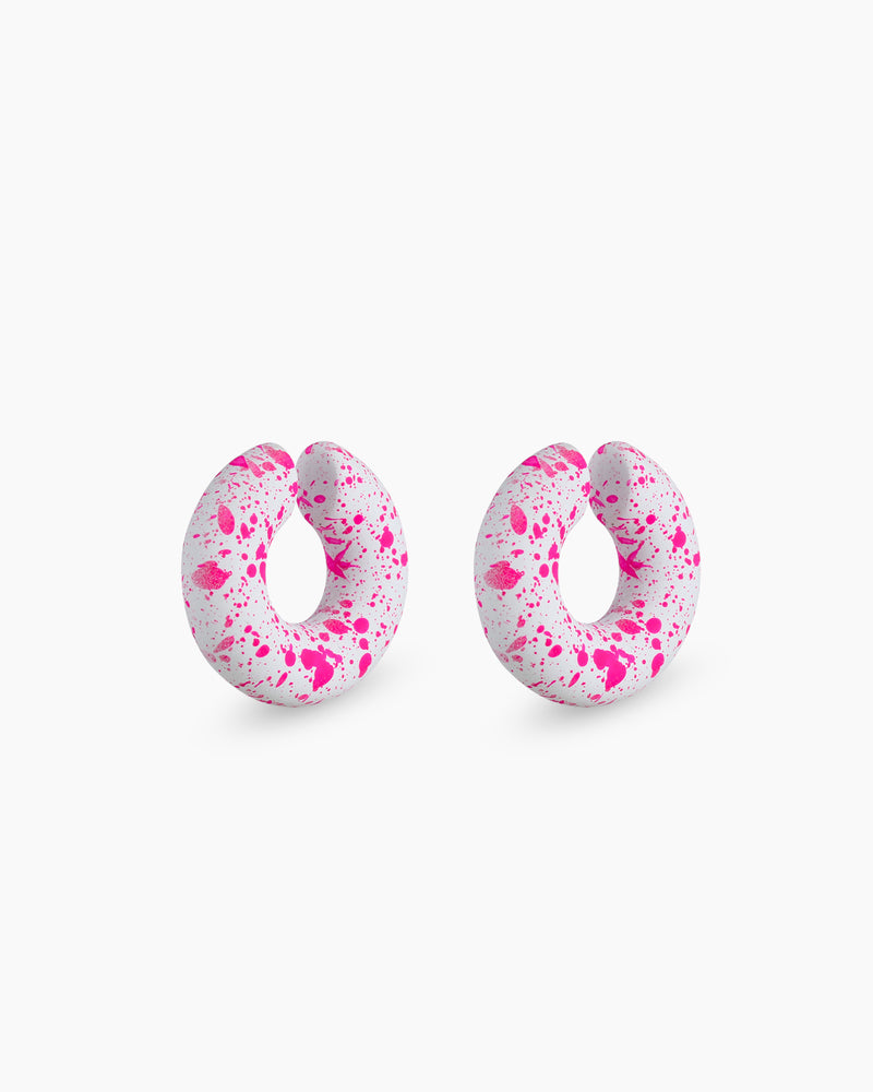 Chunky pink ear cuffs with a sculptural donut silhouette and an abstract hand-painted splatter design