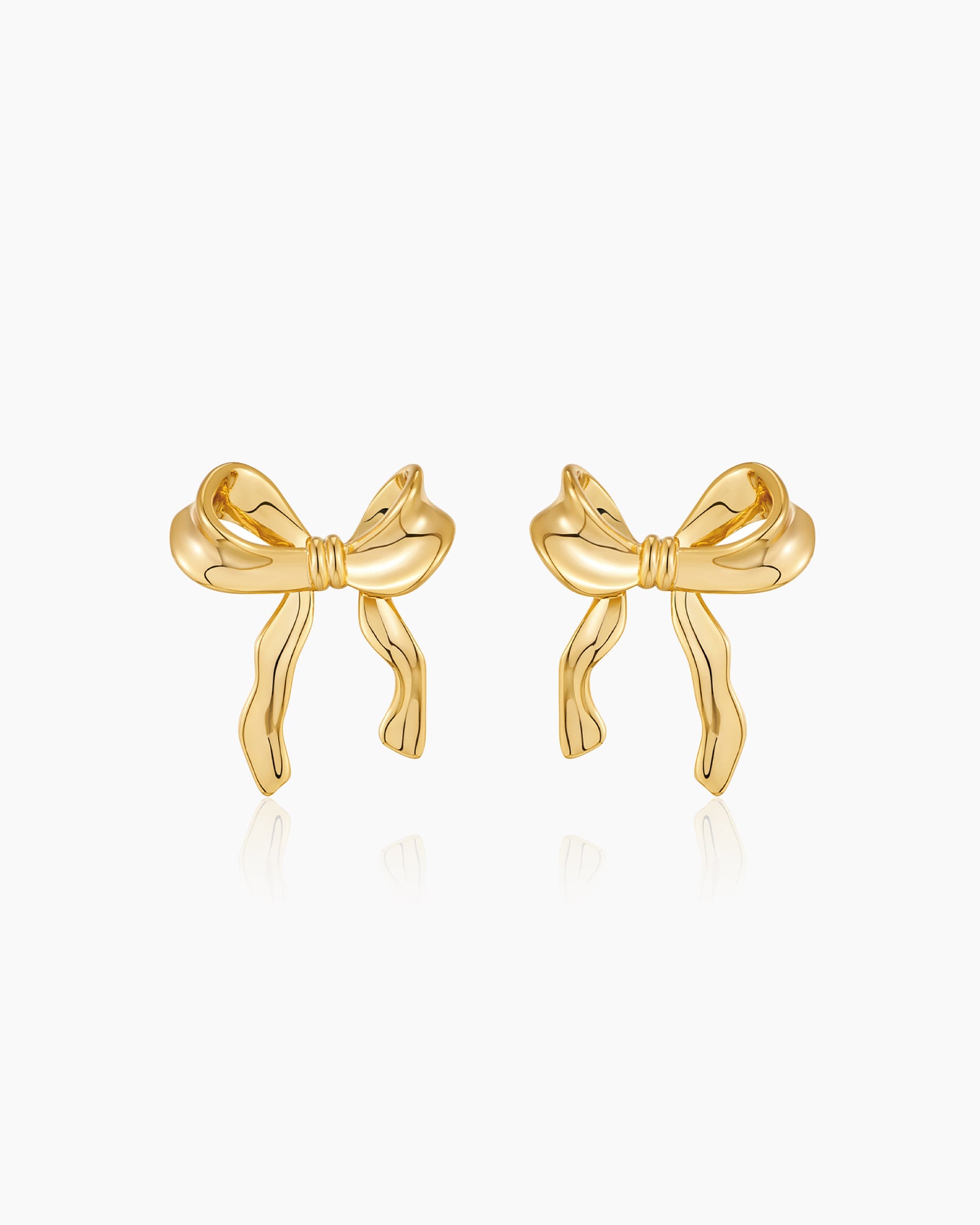 Sculptural large gold bow earrings with soft curves and wavy edges for a polished, playful look