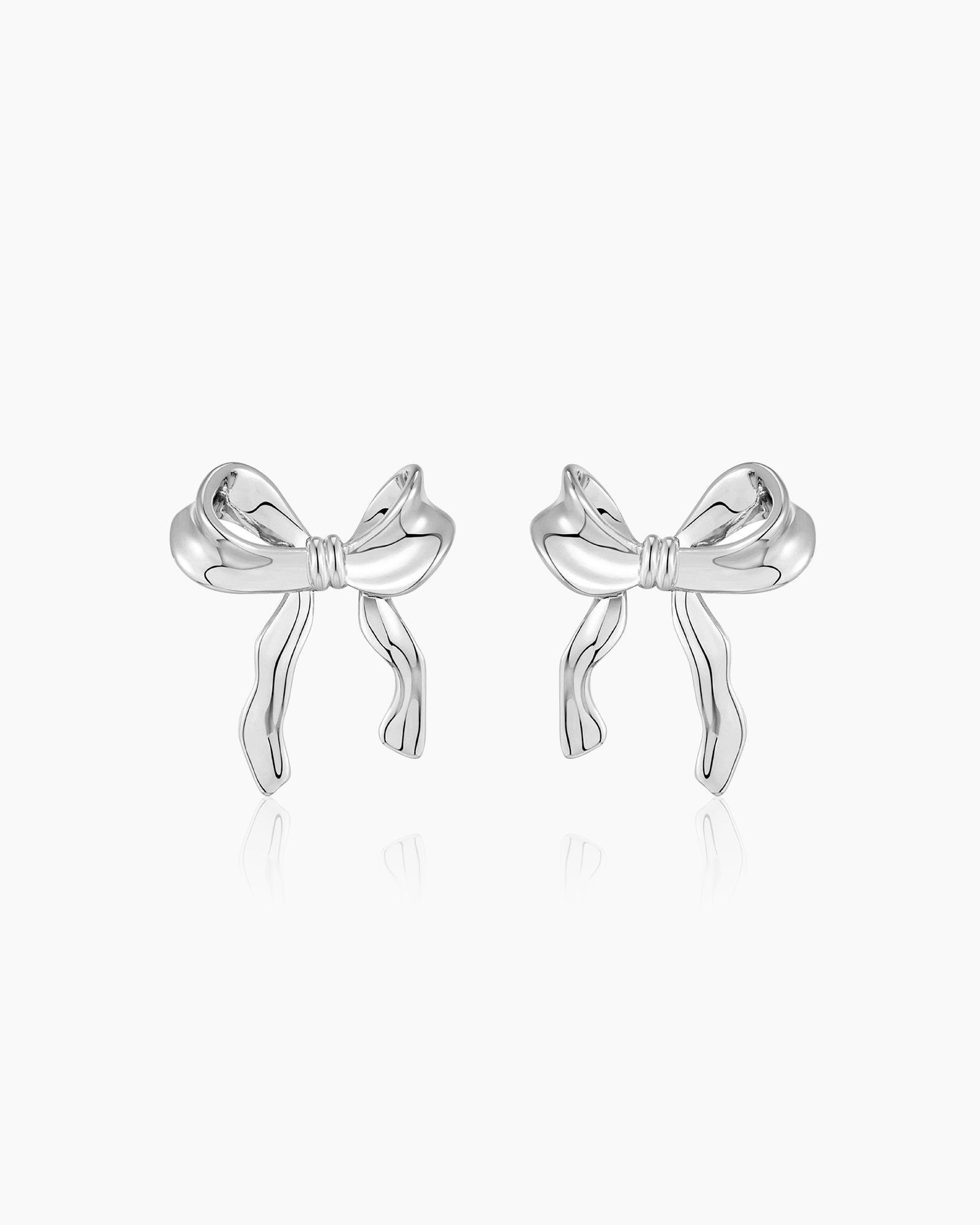 Sculptural large silver bow earrings with soft curves and wavy edges for a polished, playful look