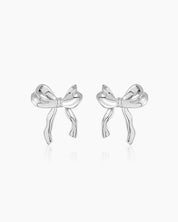 Sculptural large silver bow earrings with soft curves and wavy edges for a polished, playful look