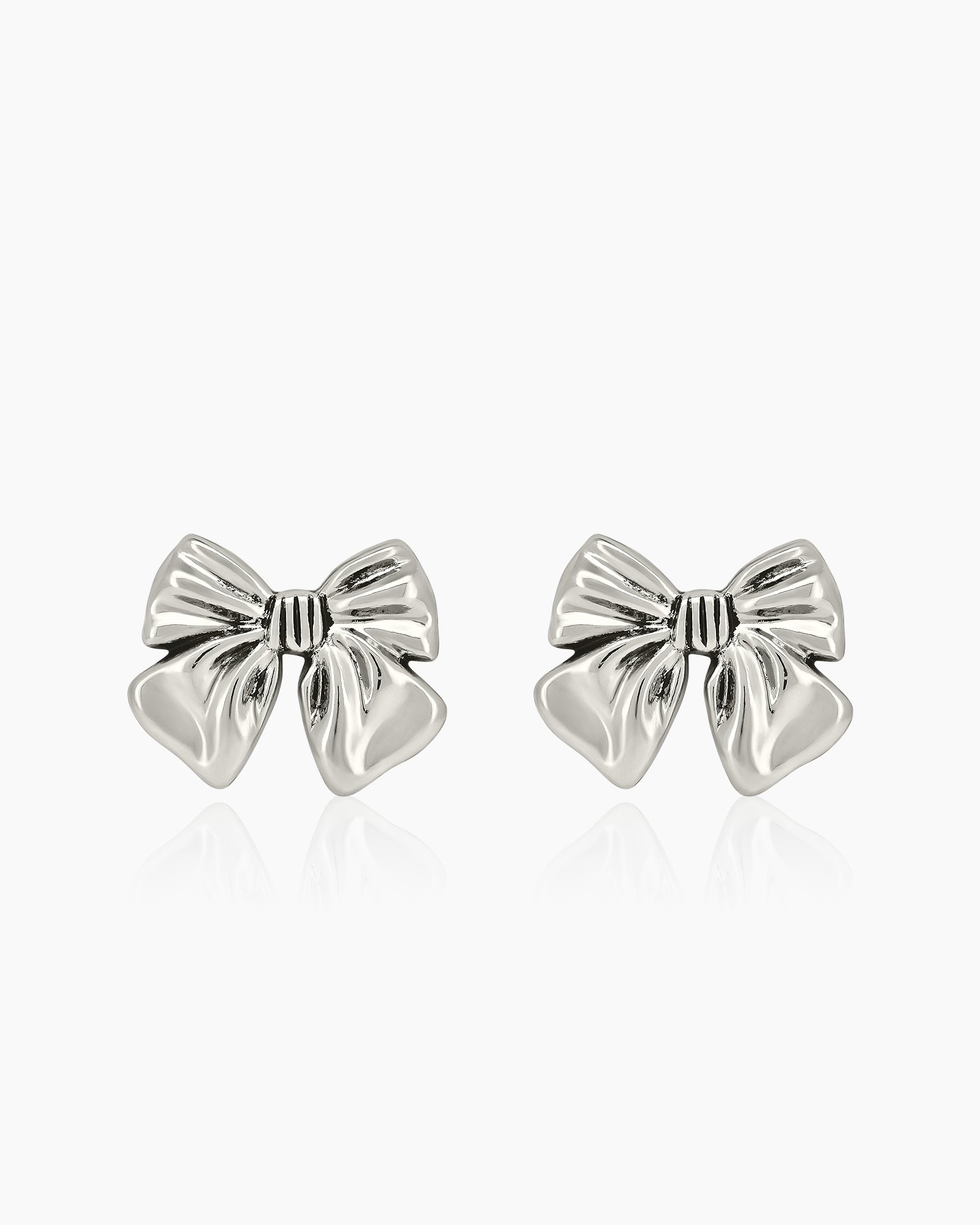 Sculptural large silver bow stud earrings with smooth curves for a playful yet refined flair