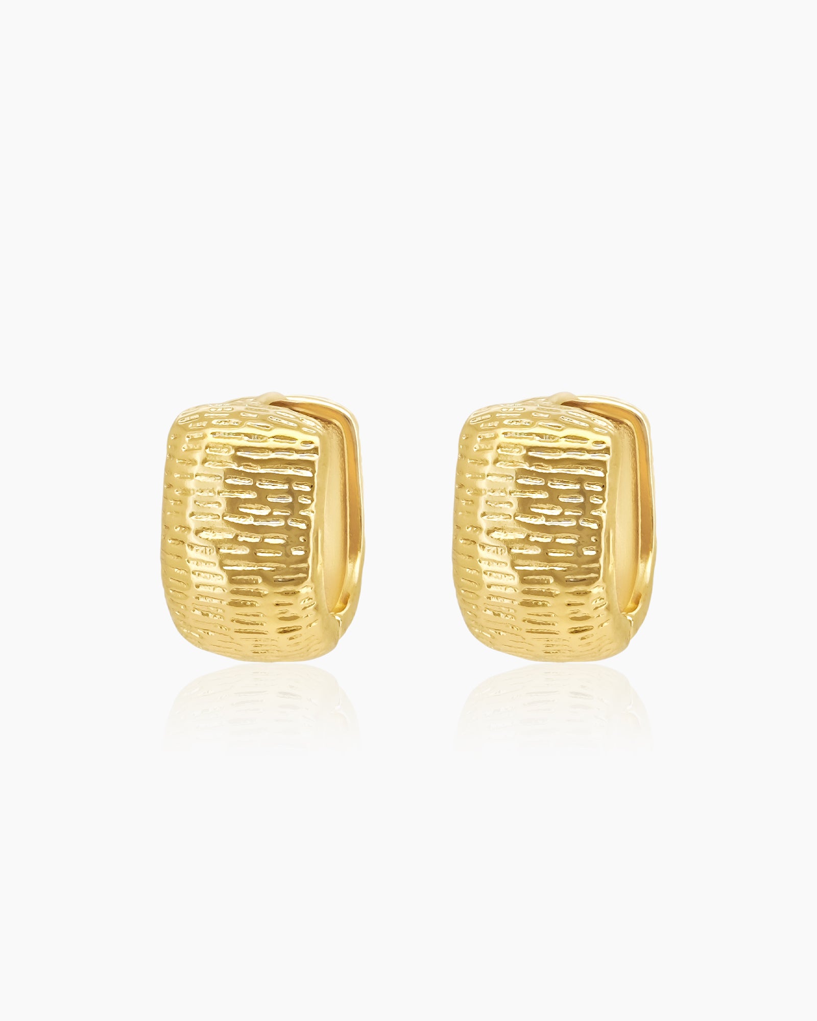 Chunky gold hoops with a sculpted, densely textured surface that creates depth and movement