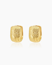 Chunky gold hoops with a sculpted, densely textured surface that creates depth and movement