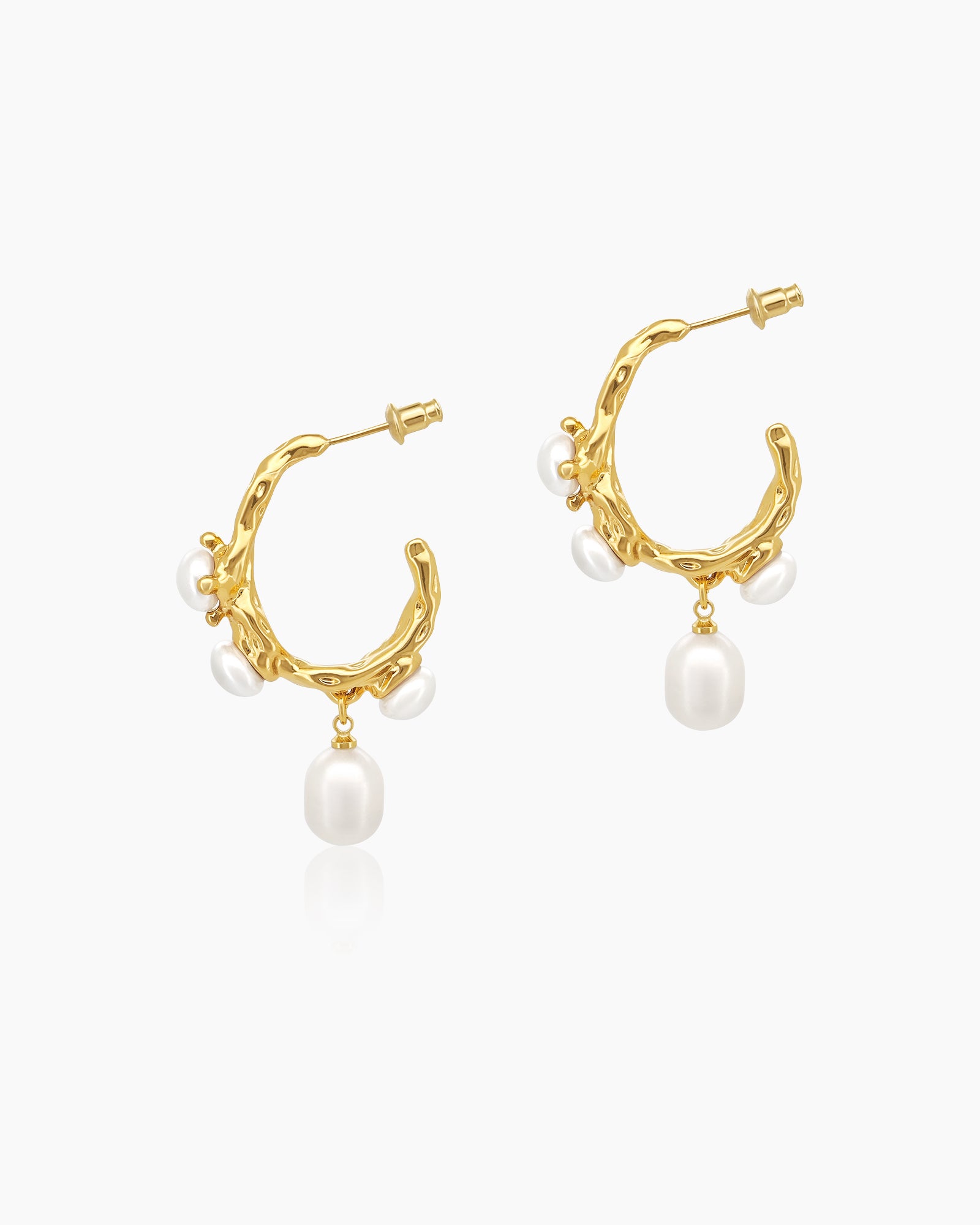 Sculptural textured gold hoops adorned with luminous freshwater pearl accents and a single swinging drop pearl