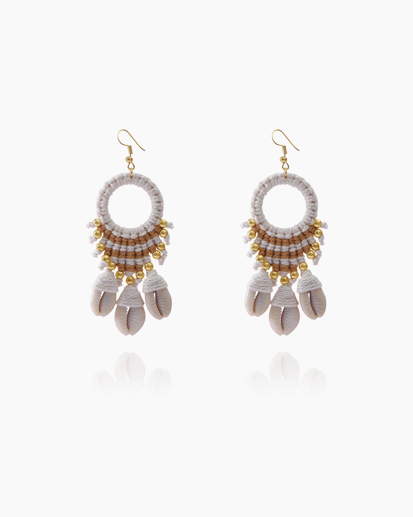 Earrings wrapped in natural fibers with gleaming gold beads and dangling cowrie shells for a boho look