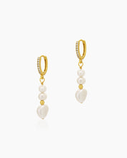 Drop earrings with a cascade of luminous pearls and golden accents, suspended from pavé-studded huggies