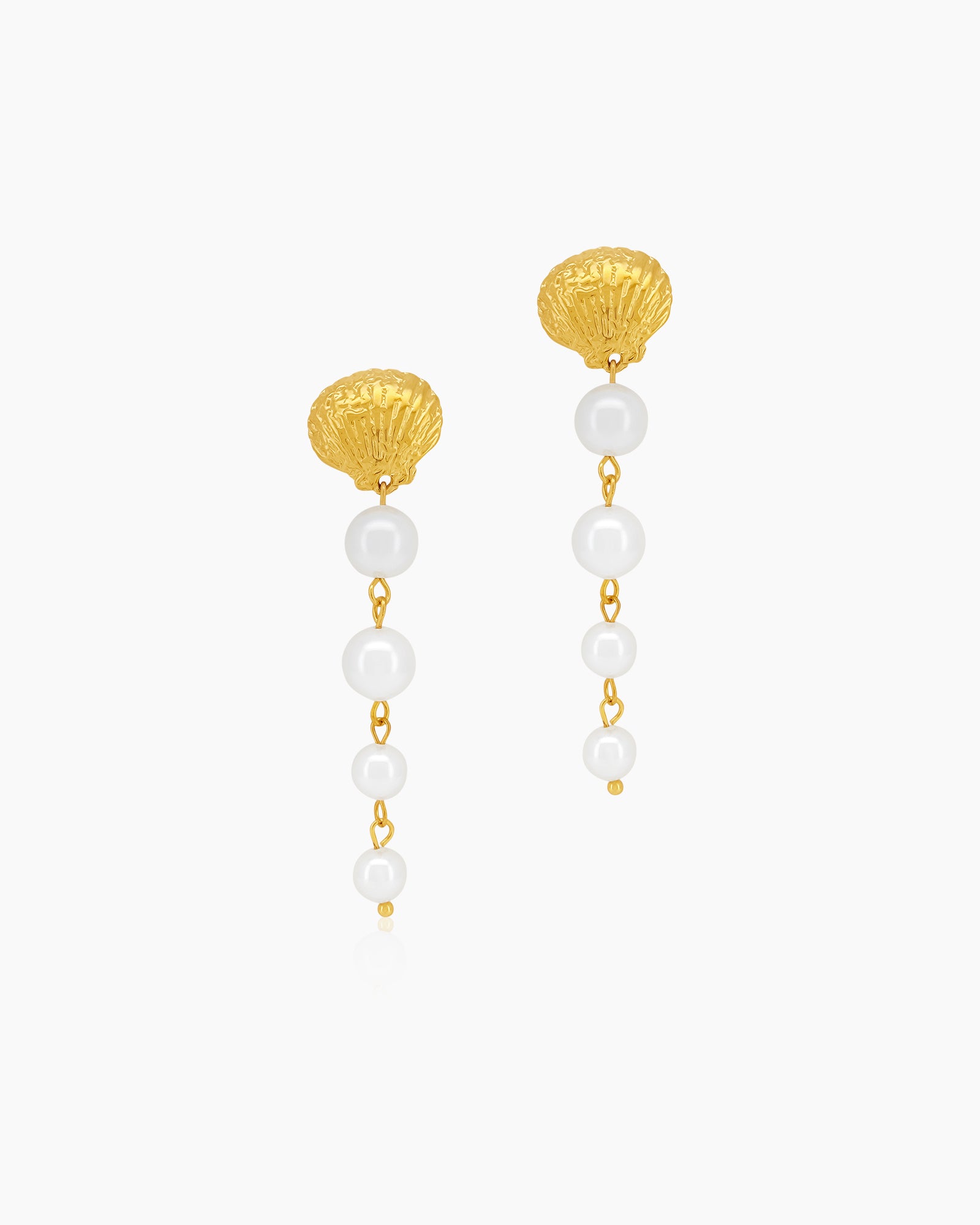 Earrings with a textured golden seashell stud anchoring a vertical drop of smooth faux pearls