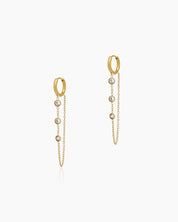 Gold-tone huggie hoops paired with two delicate cable chains adorned with bezel-framed zircon stones