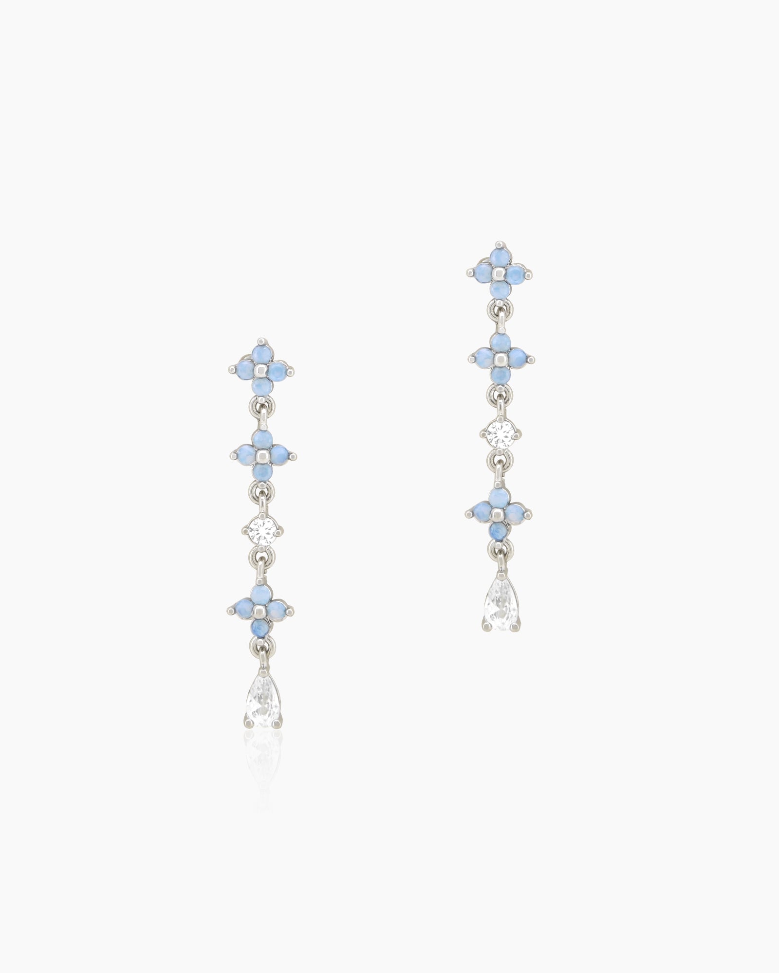 Dangle earrings in a sleek silver-tone frame with a symmetrical sequence of blue flower-like accents