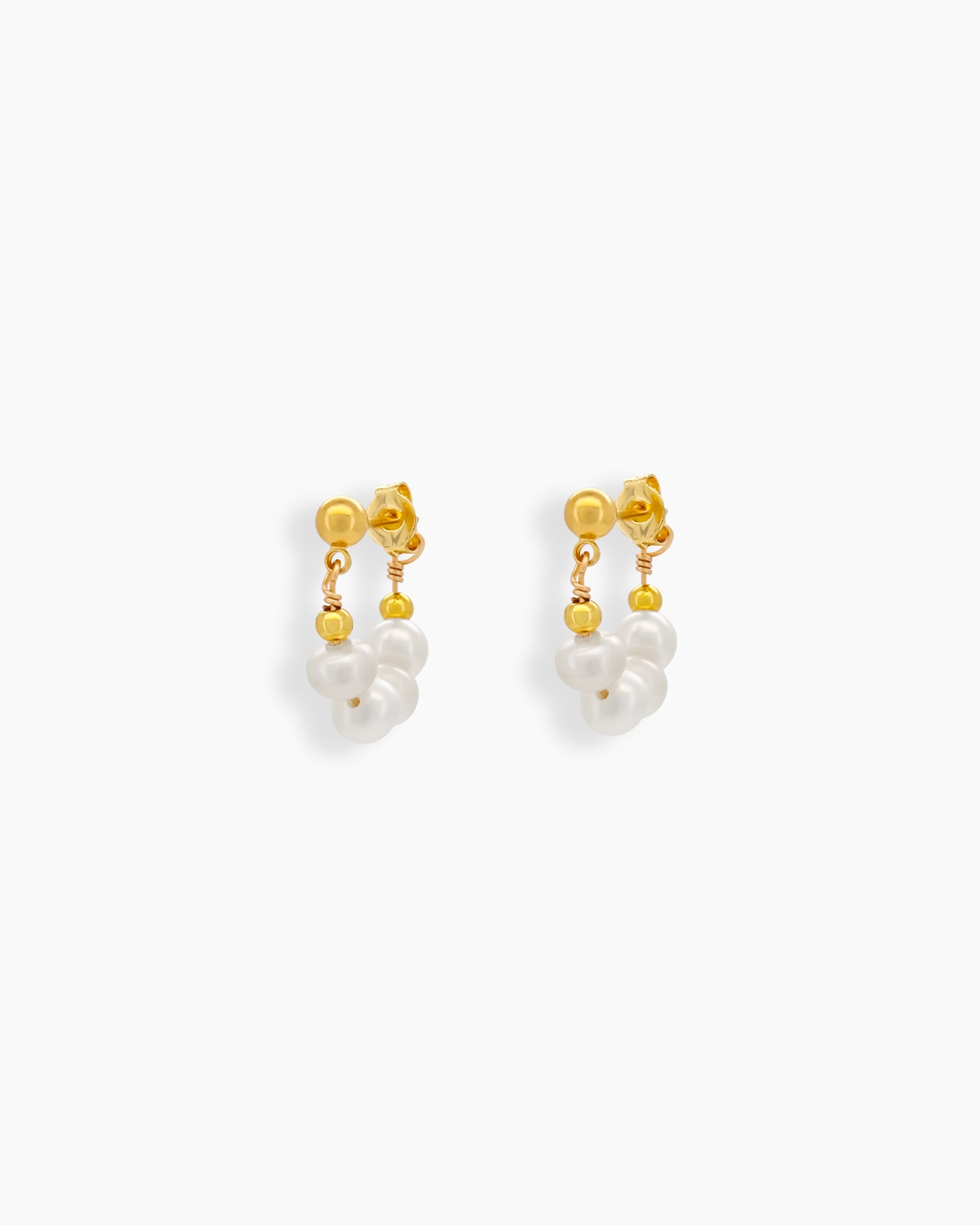 Earrings with a delicate half-hoop silhouette adorned with petite freshwater pearls on a gleaming post
