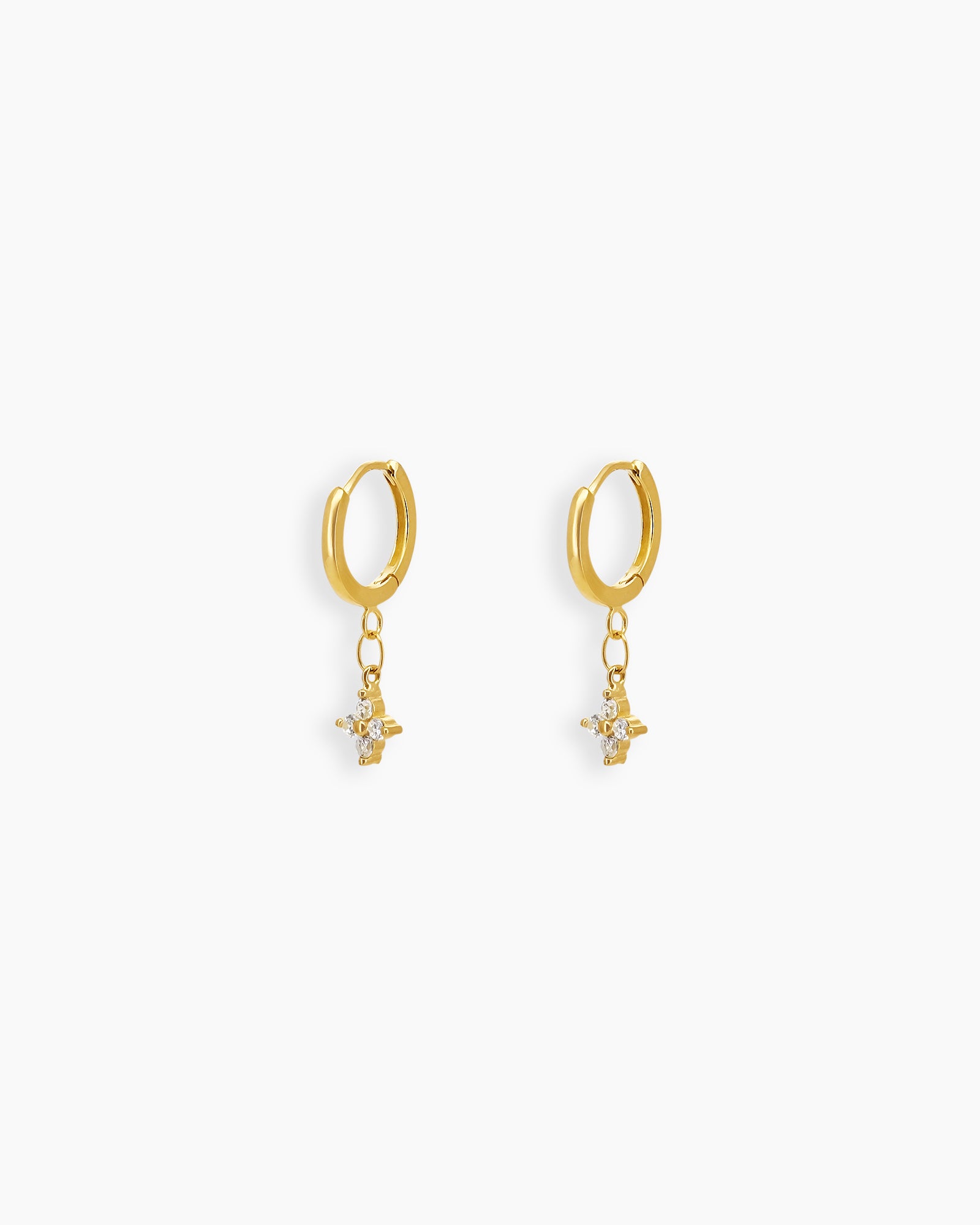 Gold-tone huggies with a delicate four-petal drop blooming with brilliant white zircon stones