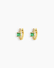 Green huggie earrings with a sleek gold-tone hoop, a baguette-cut center stone, and a delicate arc of pavé