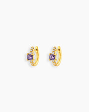 Purple huggie earrings with a sleek gold-tone hoop, a baguette-cut center stone, and a delicate arc of pavé