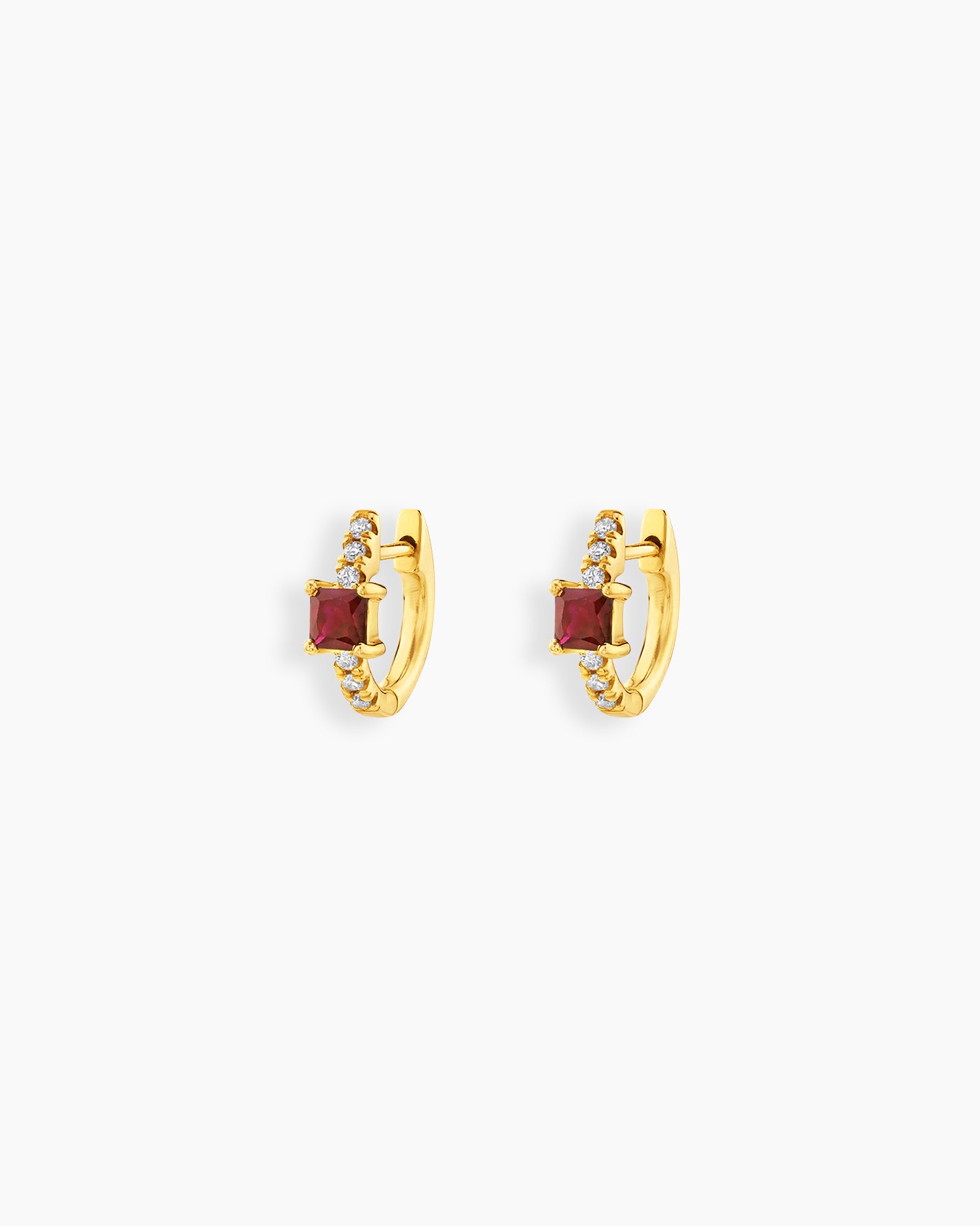 Red huggie earrings with a sleek gold-tone hoop, a baguette-cut center stone, and a delicate arc of pavé