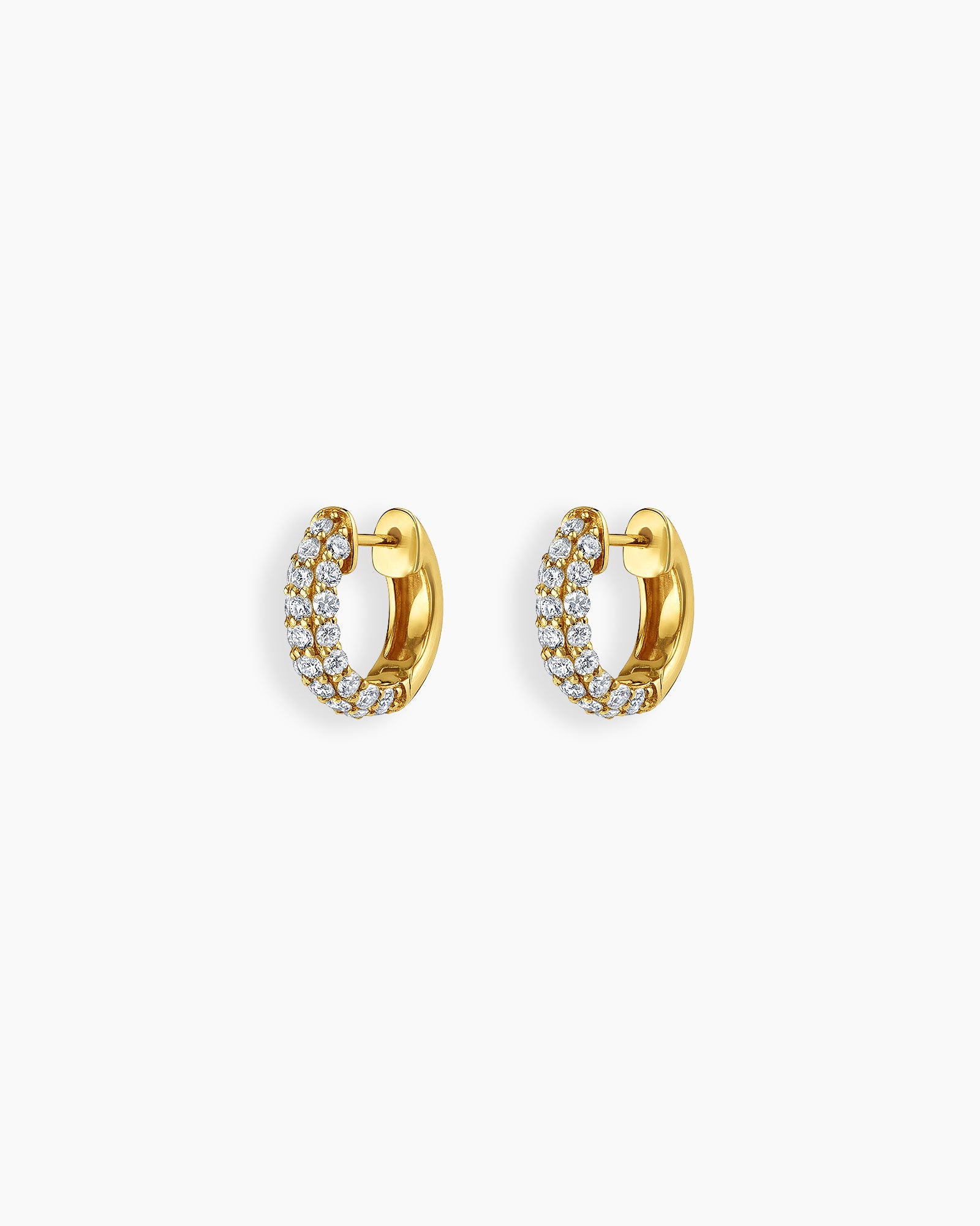 Gold-tone huggie earrings set with rows of brilliant zircon stones in a sleek, compact silhouette