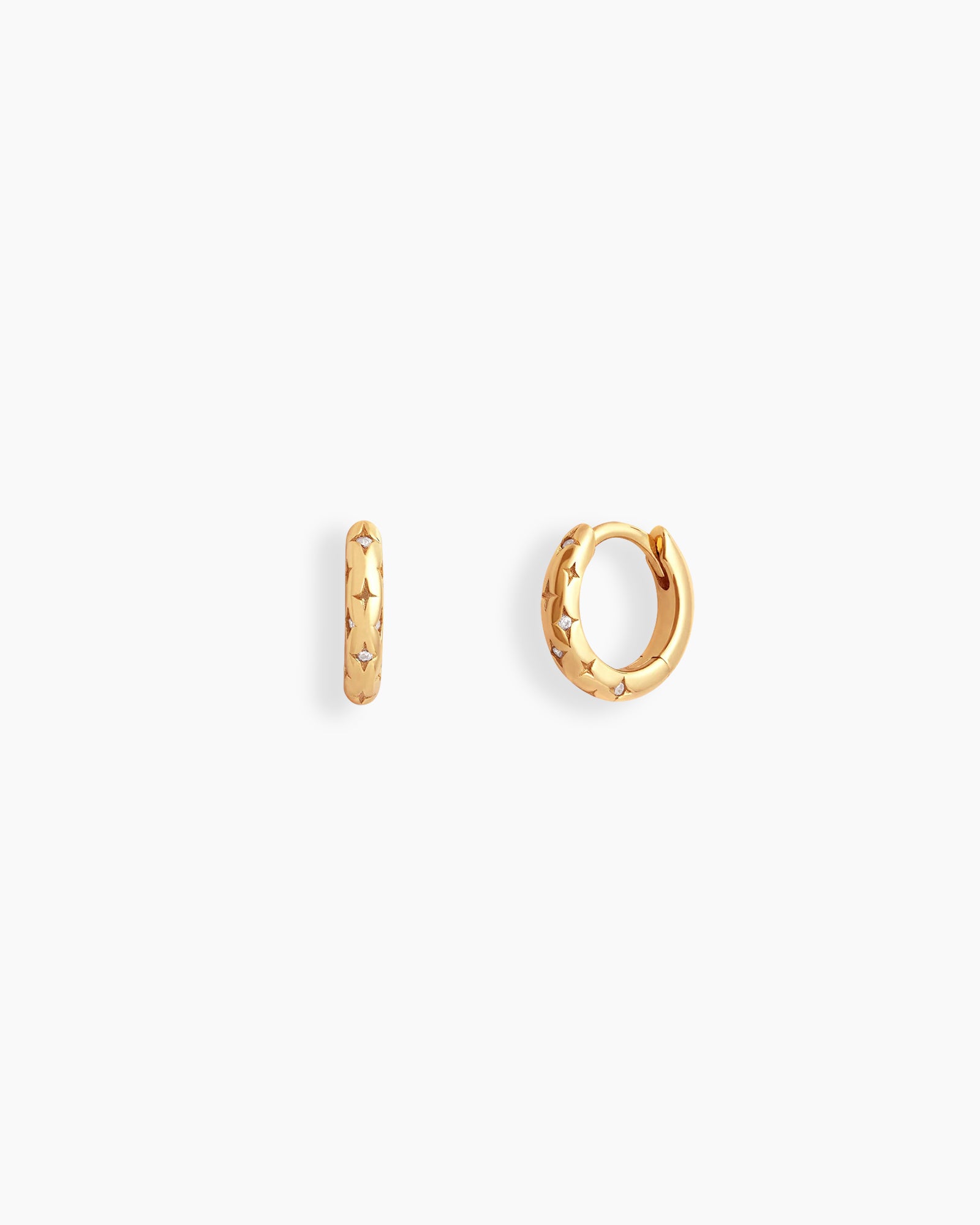 Gold chunky mini hoops engraved with dainty starbursts and a tiny white zircon stone for a cosmic feel