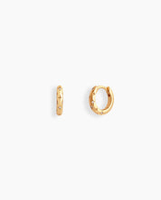 Gold chunky mini hoops engraved with dainty starbursts and a tiny white zircon stone for a cosmic feel