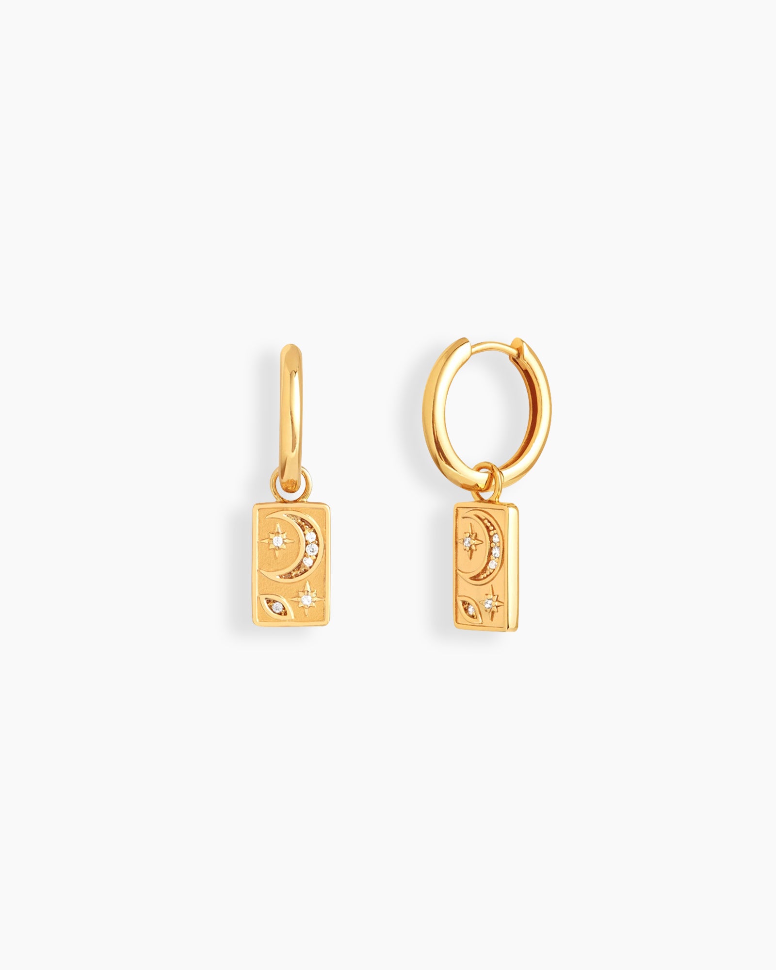 Gold huggie hoops with rectangular drops engraved in a dreamy cosmic motif of moons and stars