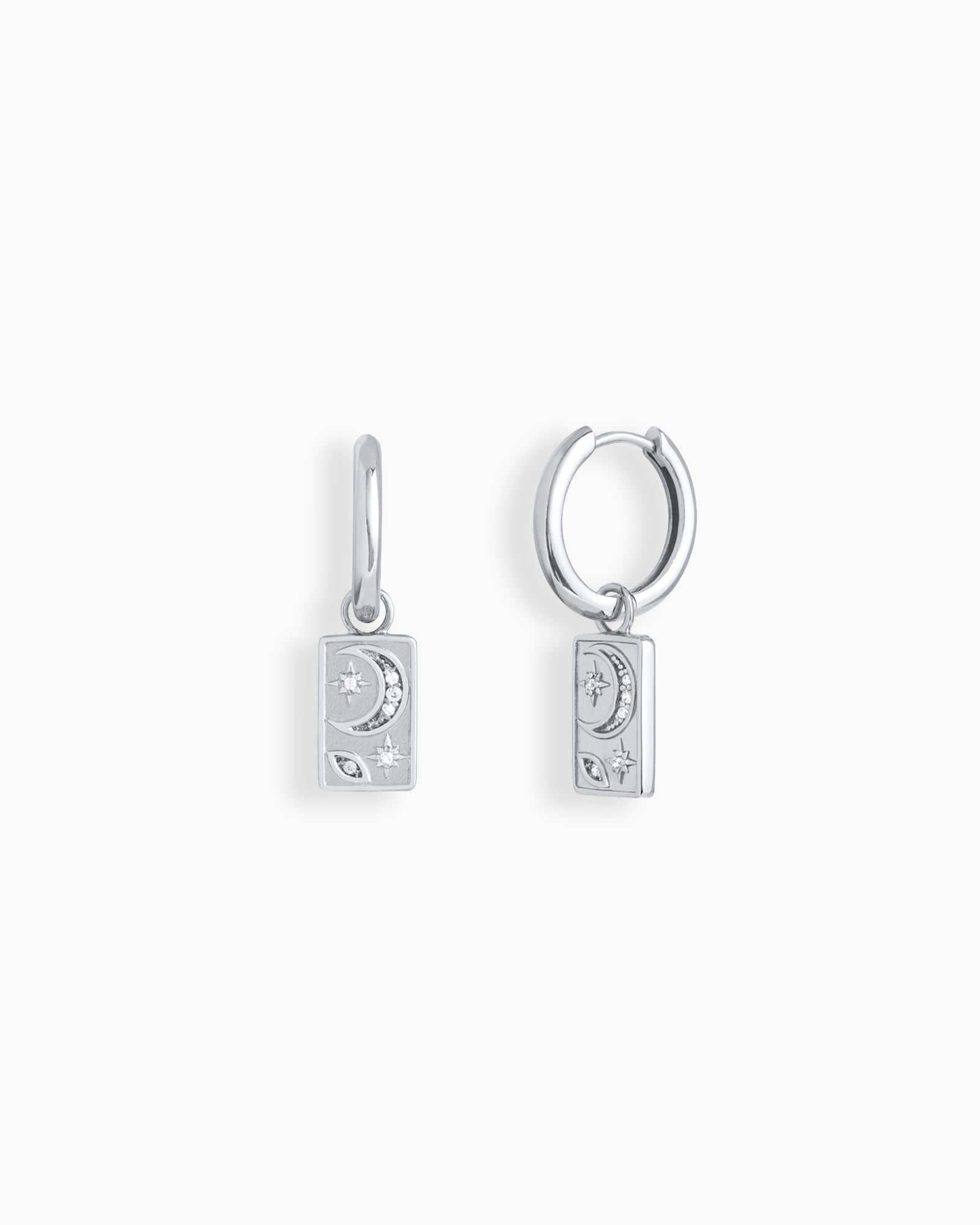Silver huggie hoops with rectangular drops engraved in a dreamy cosmic motif of moons and stars