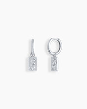 Silver huggie hoops with rectangular drops engraved in a dreamy cosmic motif of moons and stars