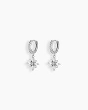 Silver huggie hoop earrings with a dainty flower-shaped charm crafted from marquise and round white zircons