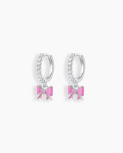 Playful silver hoop earrings with a cascade of cubic zirconia stones and a dangling soft pink enamel bow