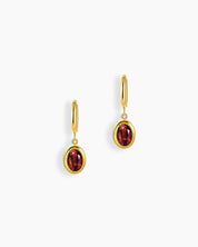 Red stone drop earrings with a richly hued oval-cut zircon in a polished gold bezel