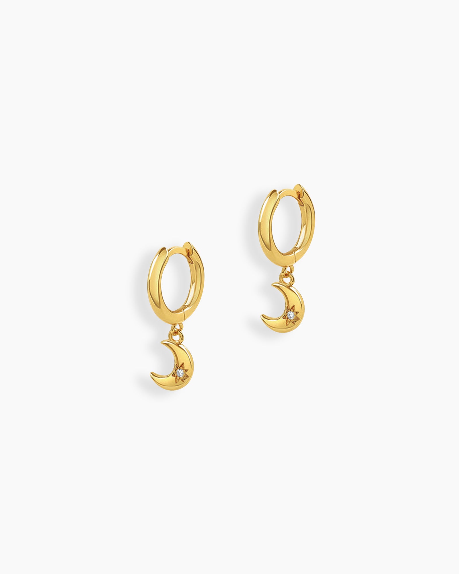 Gold drop earrings with polished huggie hoops and crescent moon charms engraved with starbursts