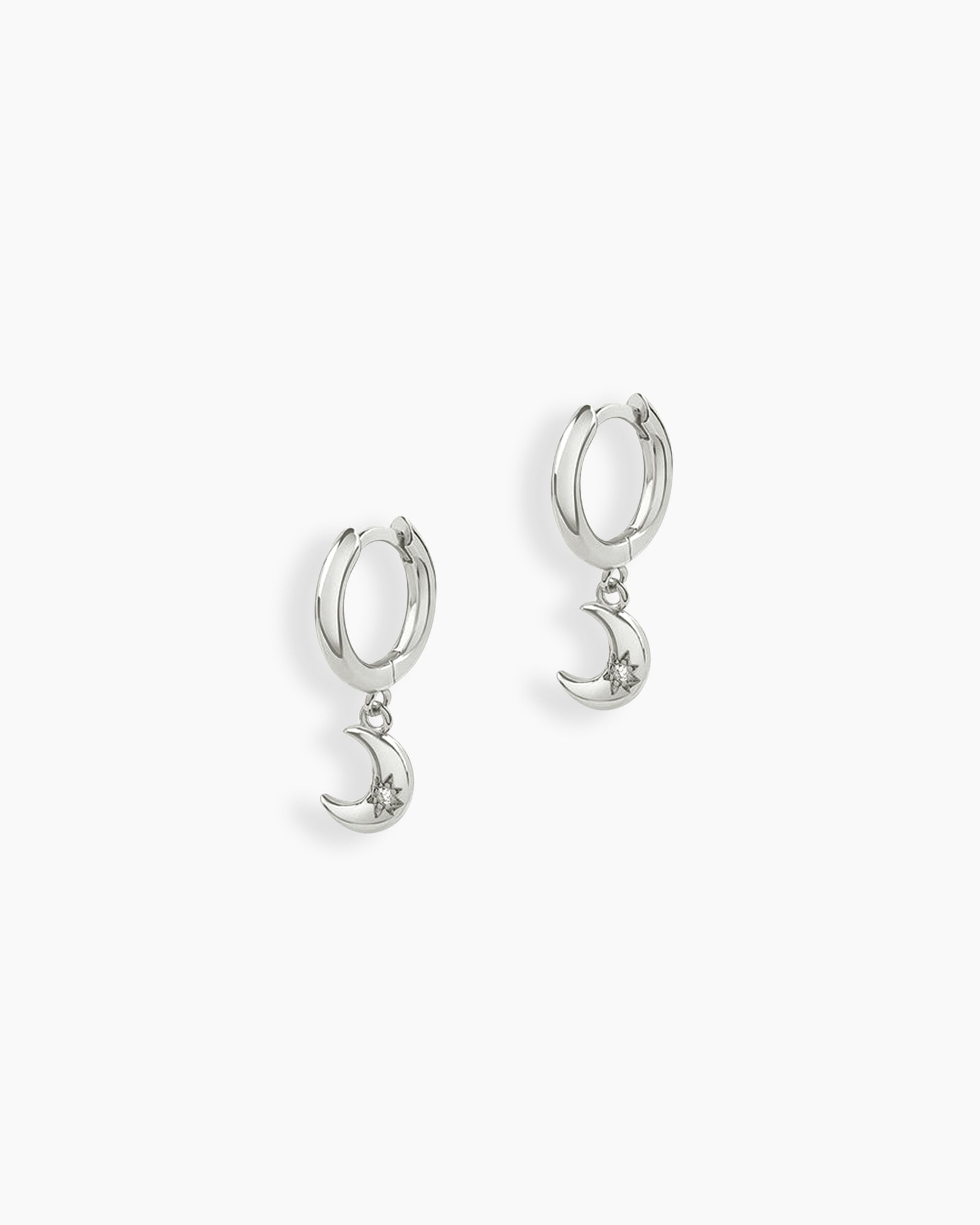 Silver drop earrings with polished huggie hoops and crescent moon charms engraved with starbursts