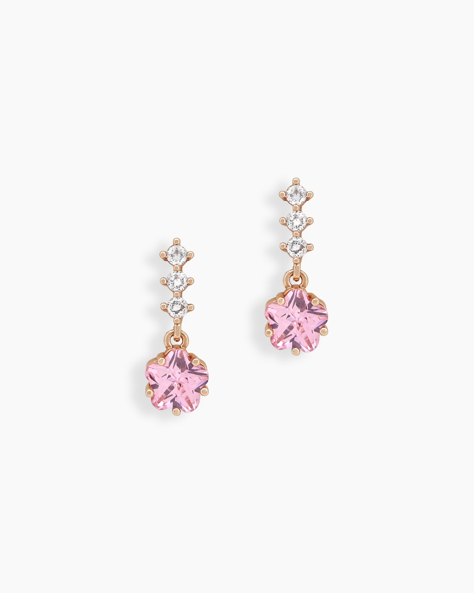 Drop earrings with a trio of dazzling white zircons leading into a dreamy, star-shaped pink crystal charm