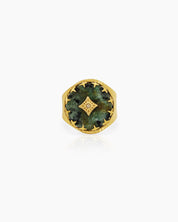 An adjustable ring with a textured gold band and a green african pine center stone, crowned by a crystal