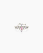 A ring set with a delicate open-heart silhouette and a sparkling pink heart stone for a magical look