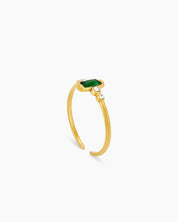 An adjustable ring with a slim, open-band silhouette and a rich green baguette-cut zircon stone