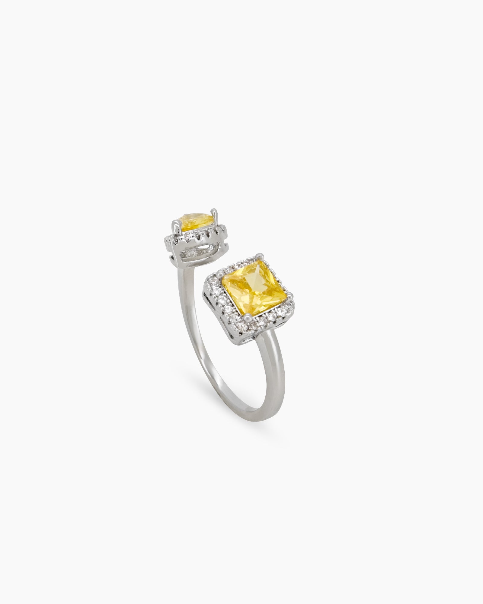 A yellow open-front ring with a pavé-framed square-cut zircon and a pear-cut stone for a bold look