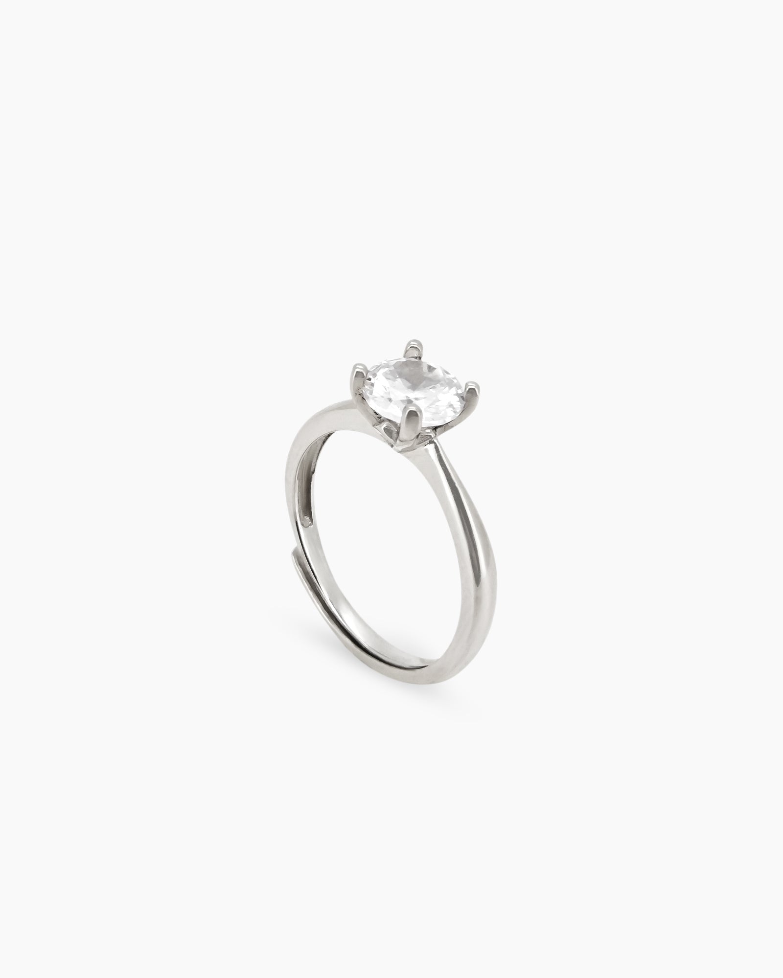 An adjustable ring with a brilliant-cut white zircon stone in a classic four-prong setting on a minimal band