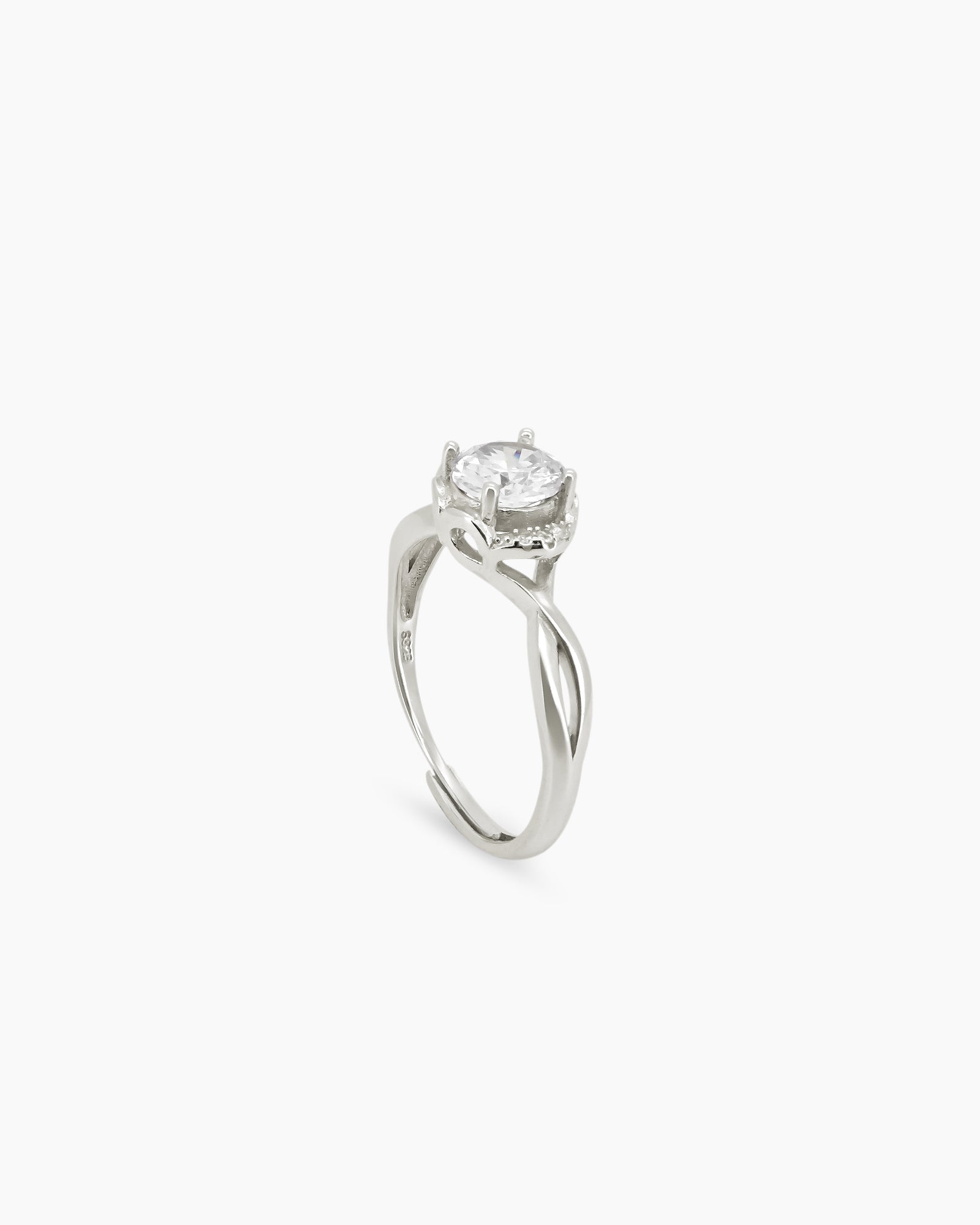 A ring with a brilliant round-cut zircon in a four-prong setting, framed by a graceful split crystal band