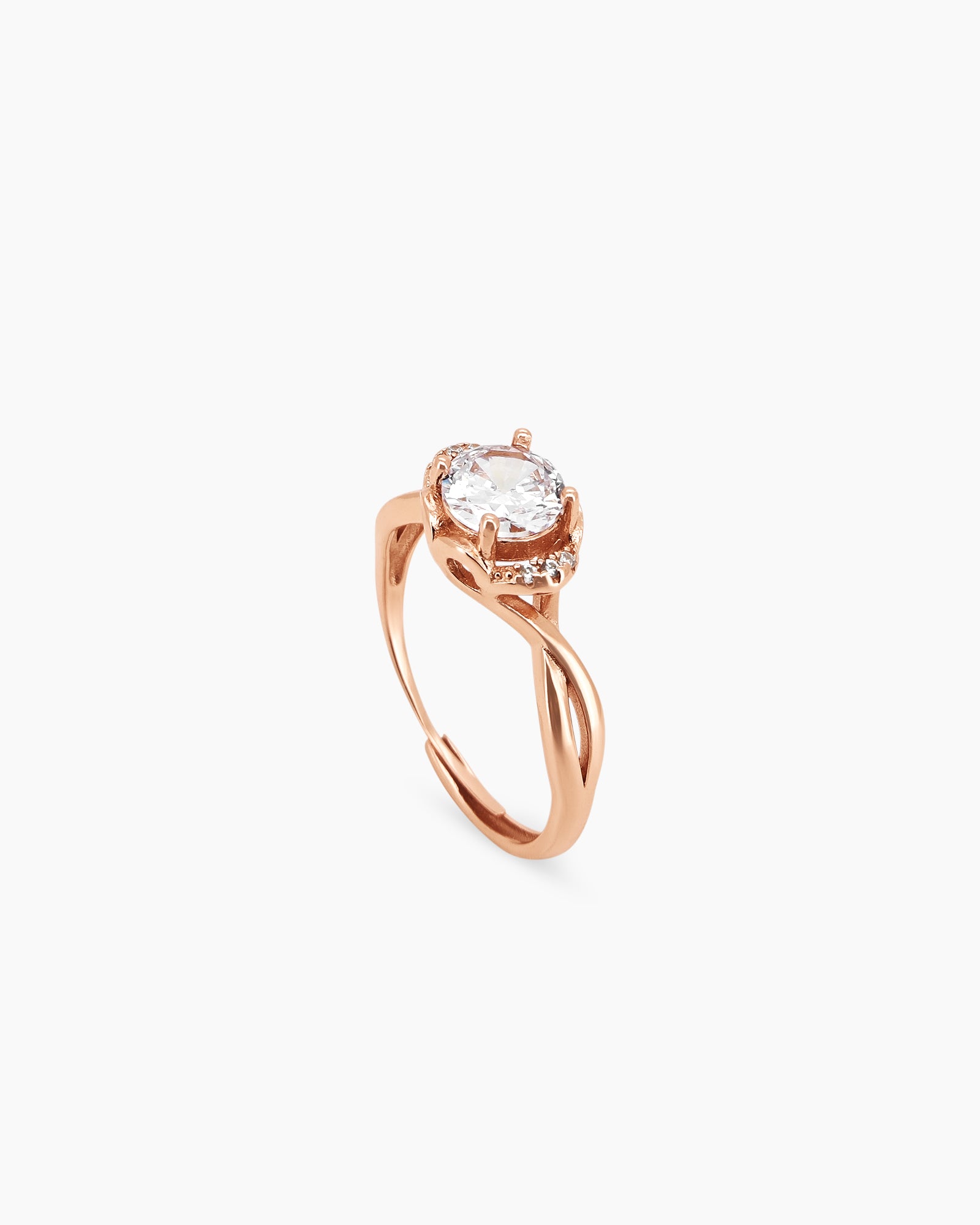 A ring with a round-cut white zircon stone in a warm-toned setting, framed by a halo of smaller stones