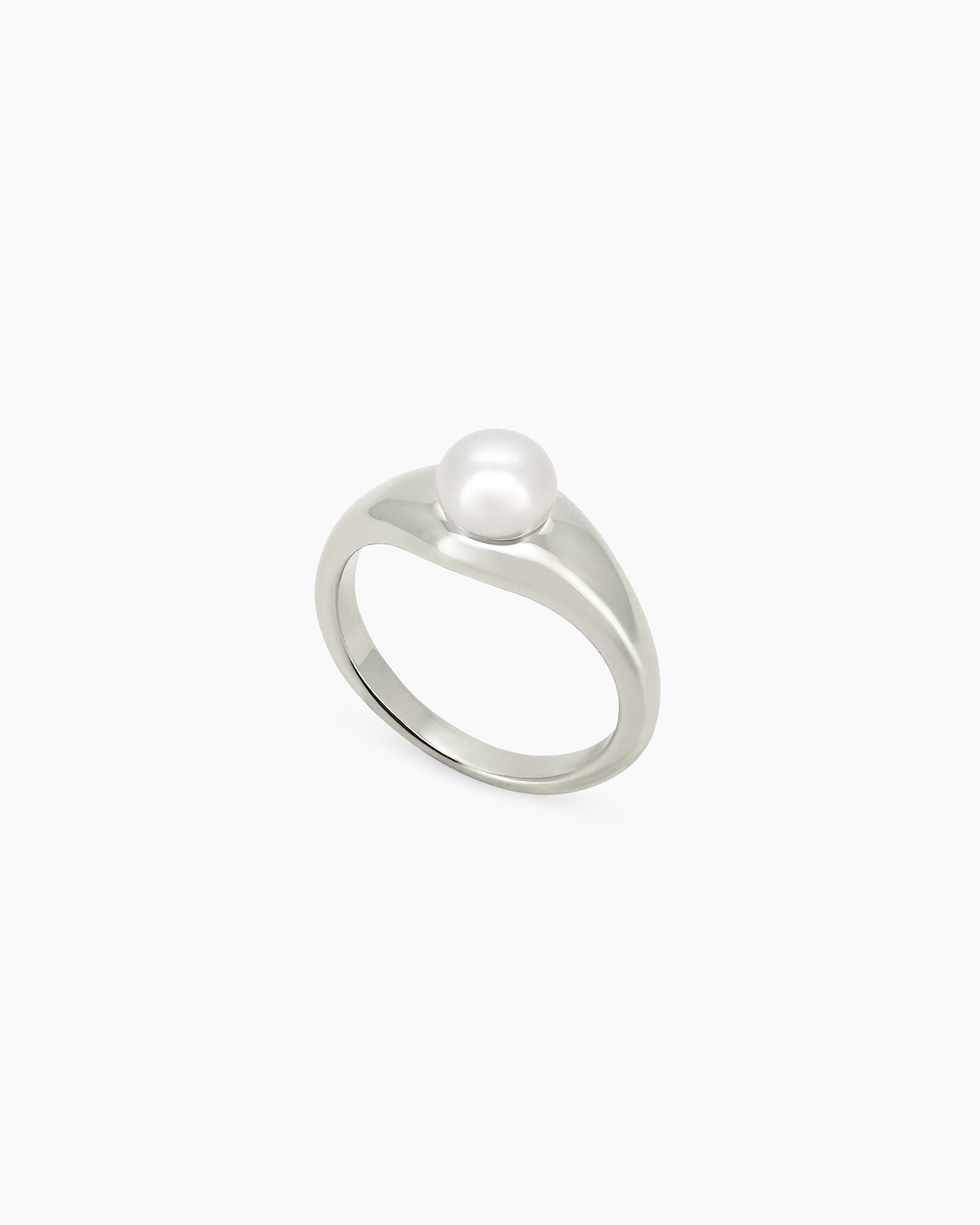 A silver ring with a fluid, sculptural band and a luminous pearl for a modern, poetic look