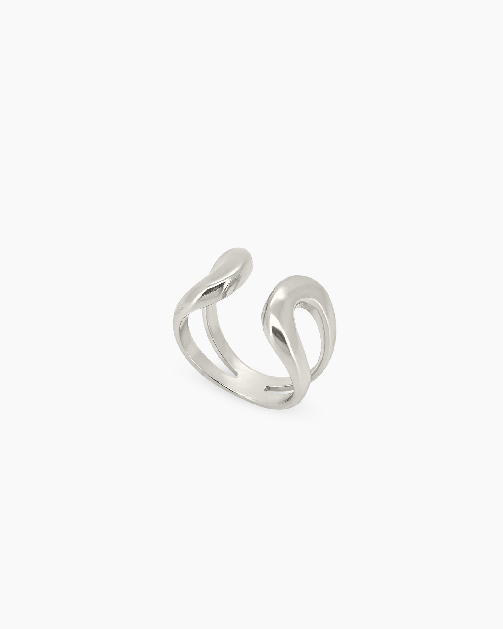 A silver open ring with a thick, smooth, and reflective curve that creates a fluid, playful presence