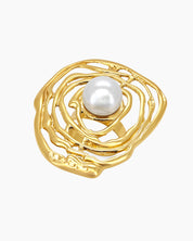 A sculptural gold ring with an abstract shell design cradling a luminous faux pearl