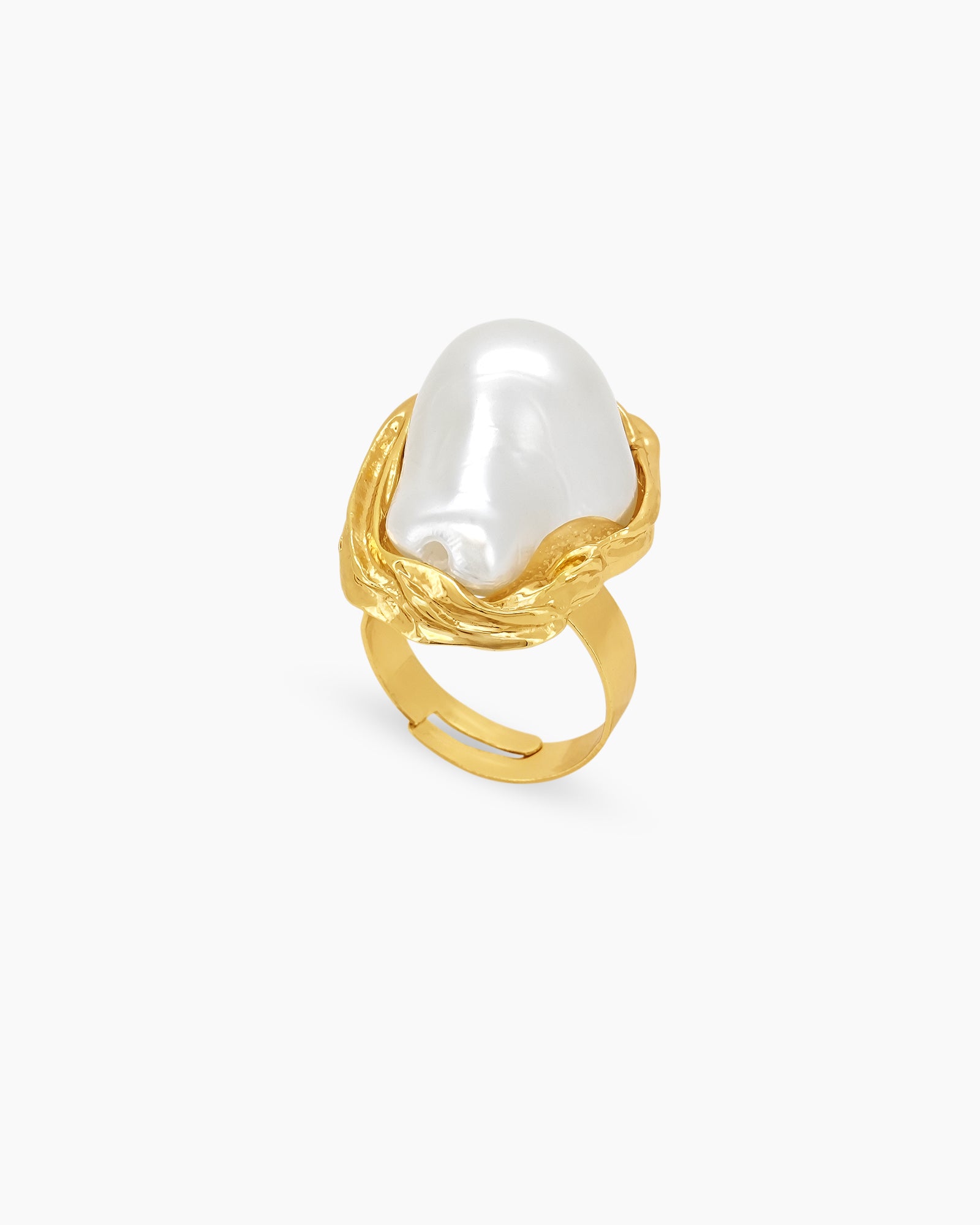 A sculptural gold ring with graceful curves and an oversized faux pearl in a textured frame