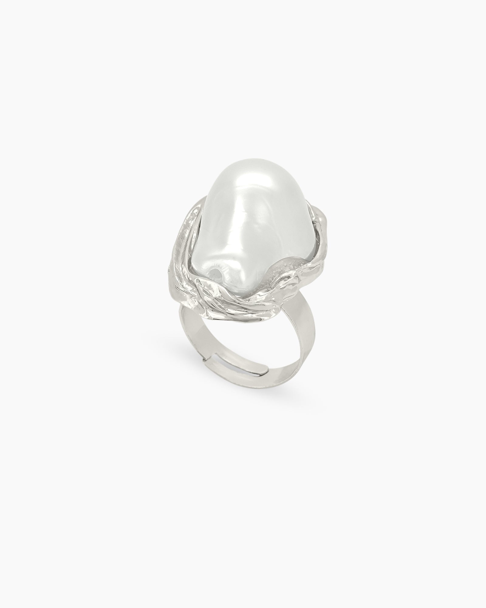 A sculptural silver ring with graceful curves and an oversized faux pearl in a textured frame