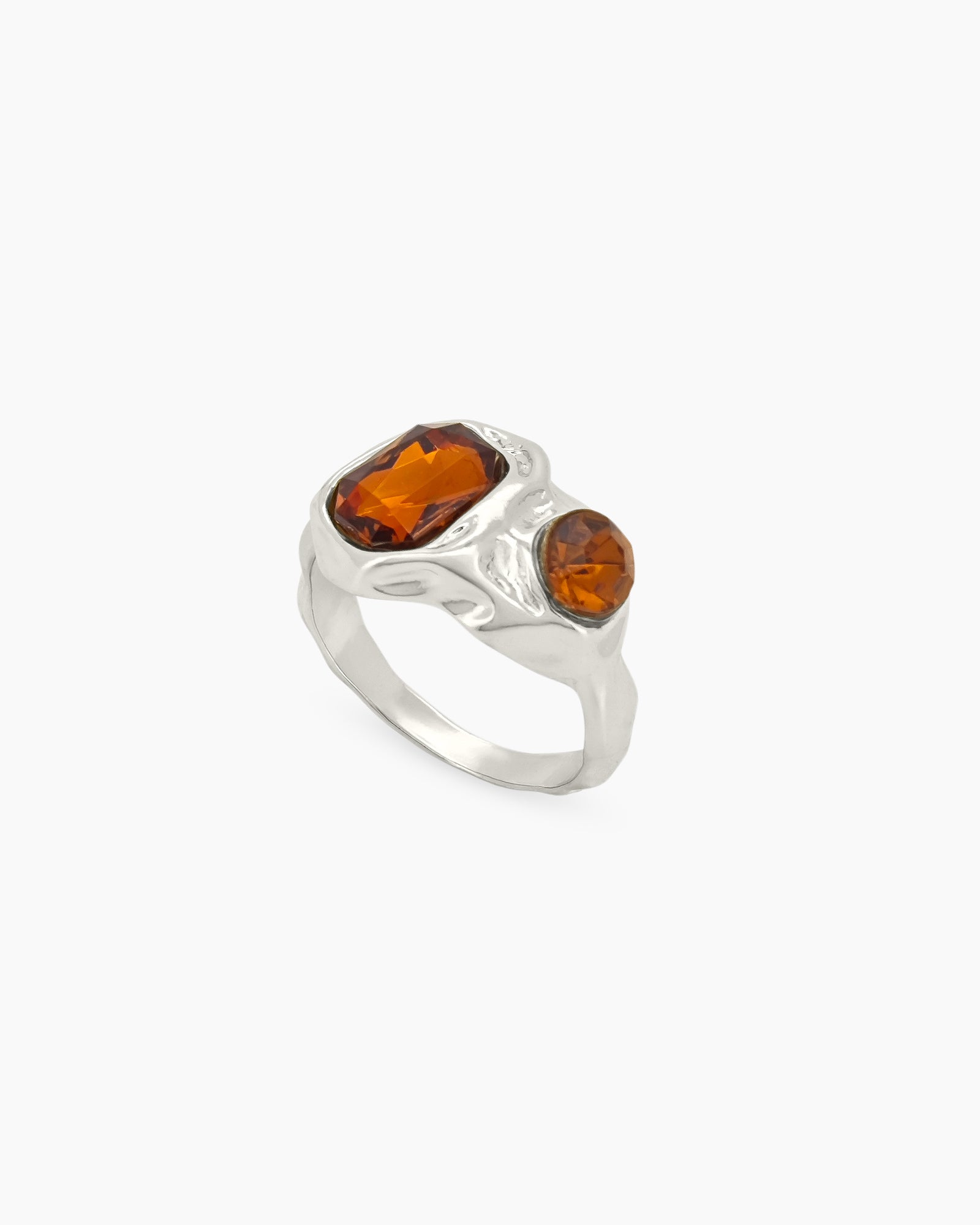 A silver vintage ring with amber-hued rhinestones and an intricately molded, molten-texture band