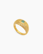 A vintage ring with a ridged gold sunburst-style band radiating around a soft green natural jade stone
